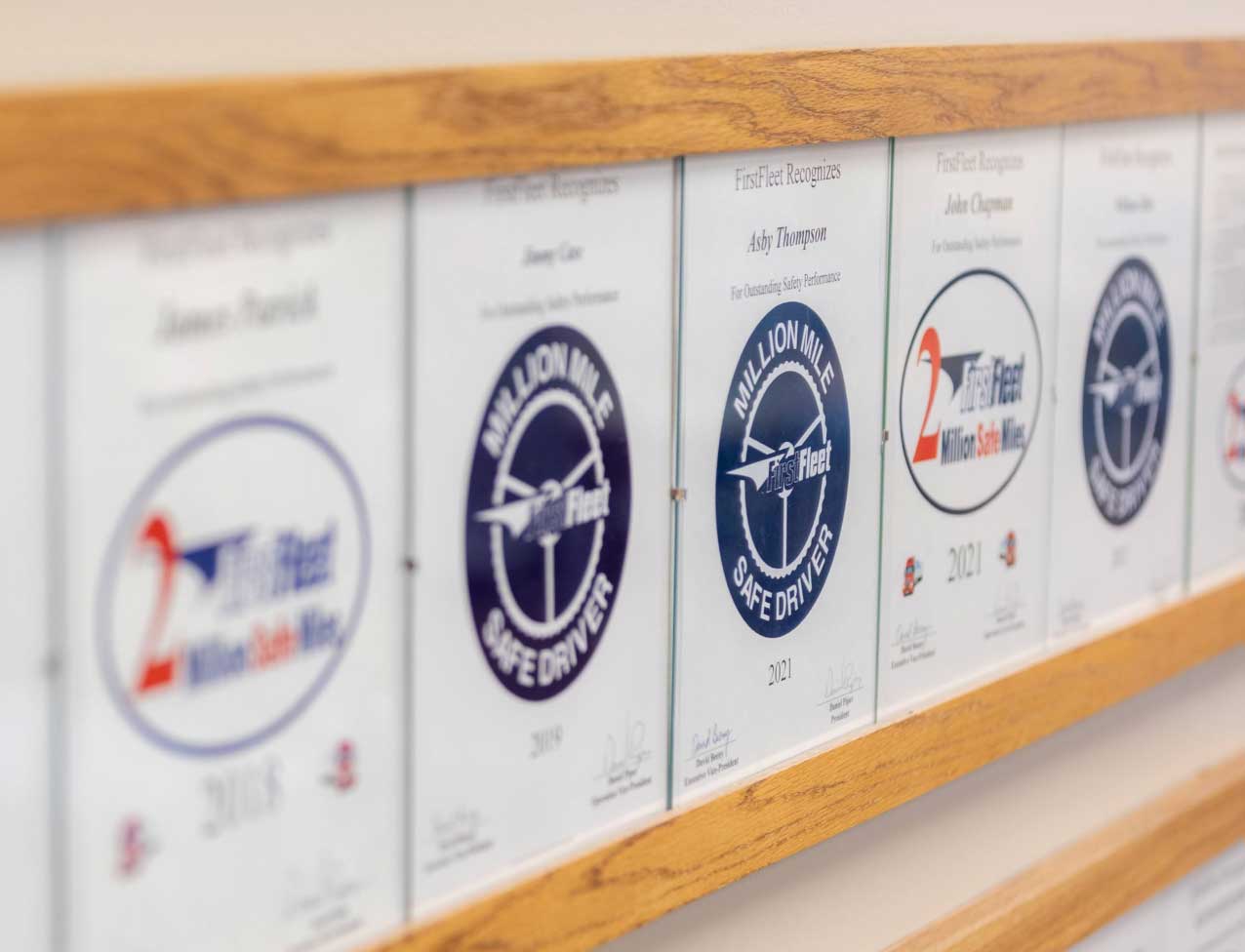 Row of framed Million Mile Safe Driver awards on wall